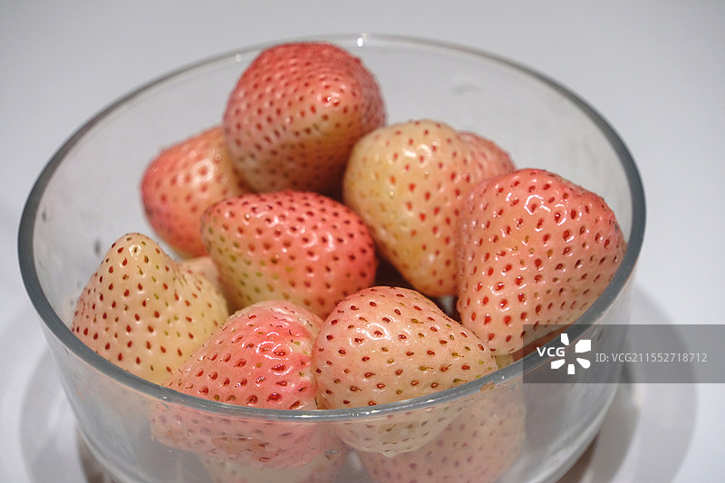 透明玻璃碗中的粉白草莓图片素材