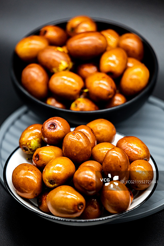 黑色背景下碗中沧州金丝小枣水果的高角度视图.河北沧州金丝小枣山东乐陵金丝小枣的相同之处图片素材