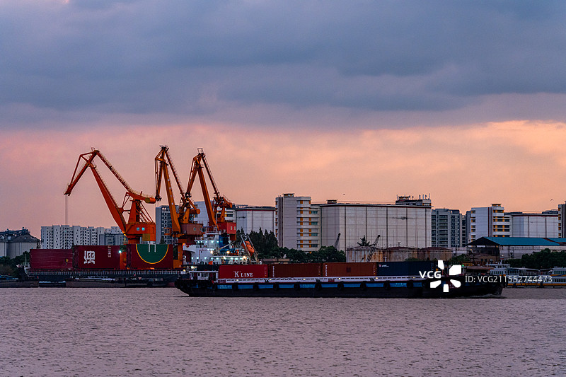 黄昏时刻的内河港口及出发的货轮图片素材