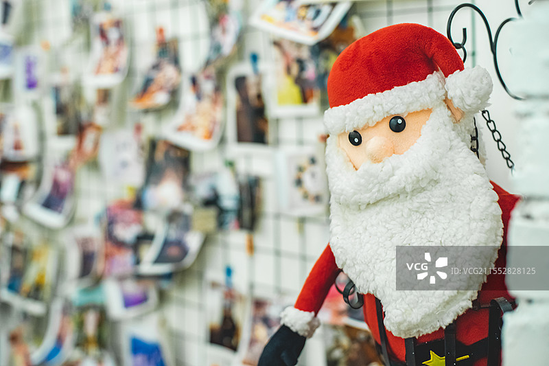 中国西方春节圣诞节拍摄主题，墙壁上张贴大量拍立得照片和圣诞老人玩偶，室内无人图像摄影图片素材