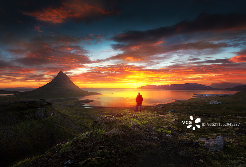 冰岛草帽山日落时站在山上的人的后视图图片素材