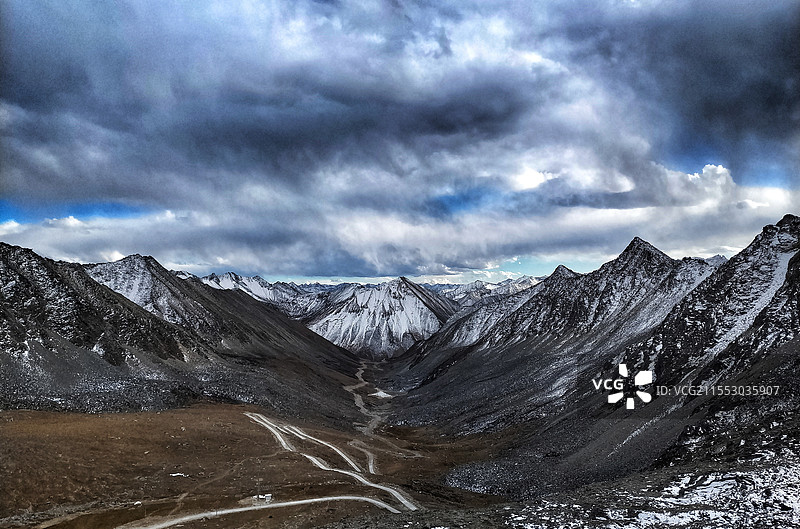乌云密布下的雪山图片素材