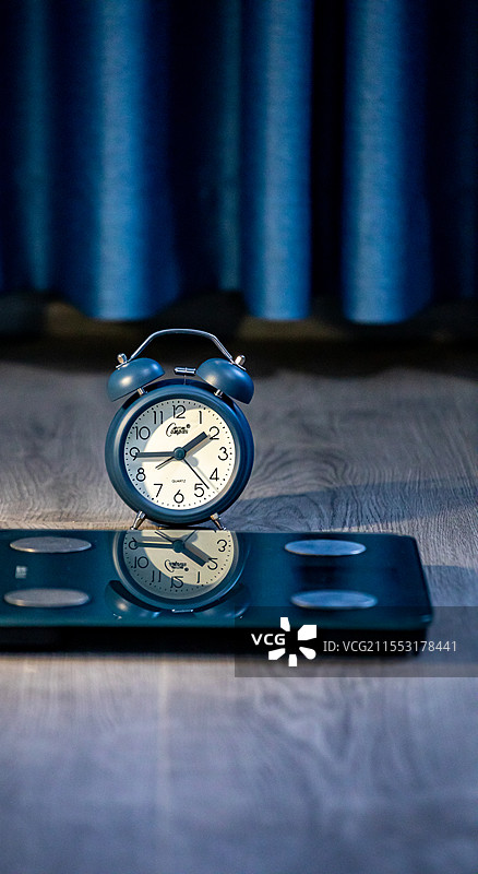 室内木地板上有闹钟的体脂秤特写镜头图片素材