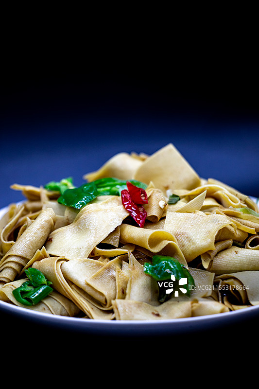 黑色背景下盘子里的东北家常菜尖椒干豆腐青椒豆腐皮家常菜特写镜头图片素材