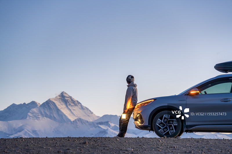 站在车旁的人提着灯看珠穆朗玛峰图片素材