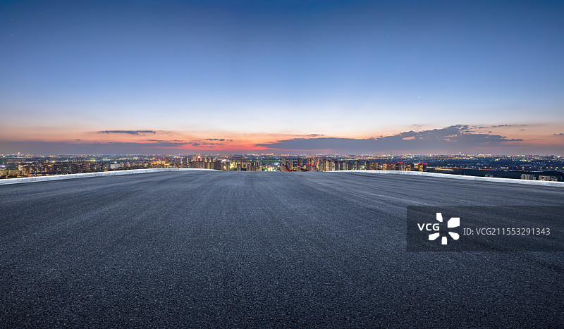 夜幕下的公路与城市天际线图片素材