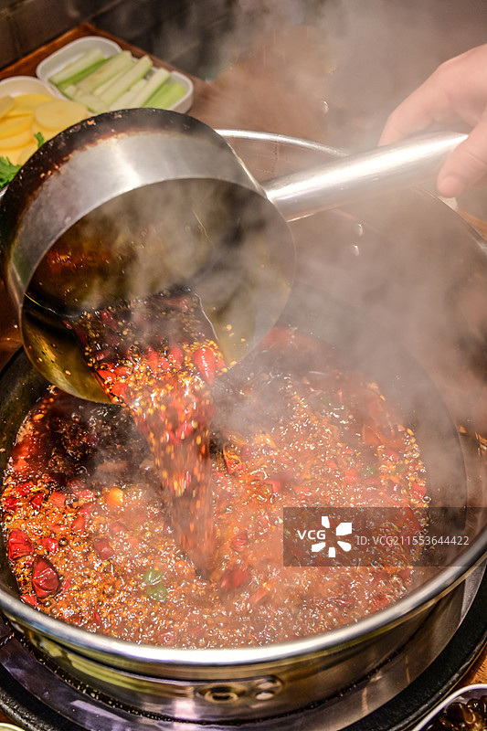 特气腾腾的油炸辣椒油导入火锅中图片素材