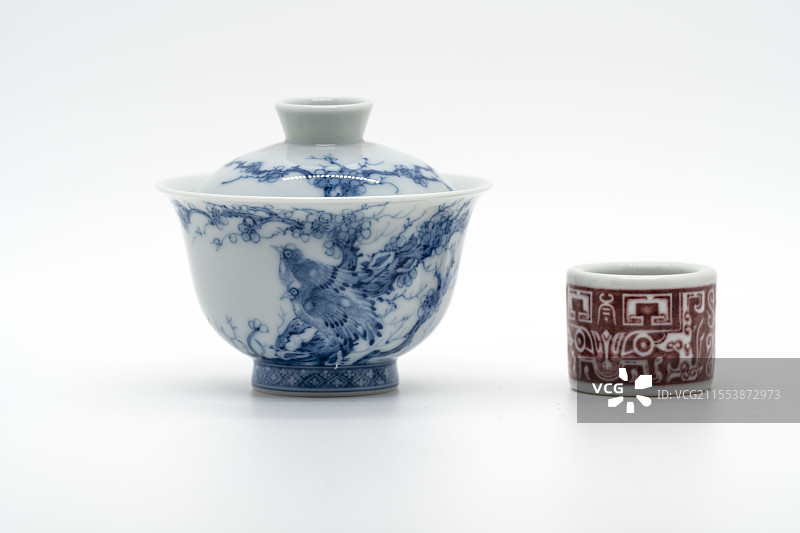 白色背景下的茶具：青花瓷盖碗与釉里红盖置图片素材