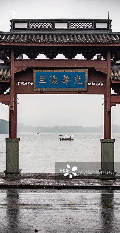 浙江杭州孤山中山公园看雨中的西湖光华复旦牌坊与湖面上的游船图片素材