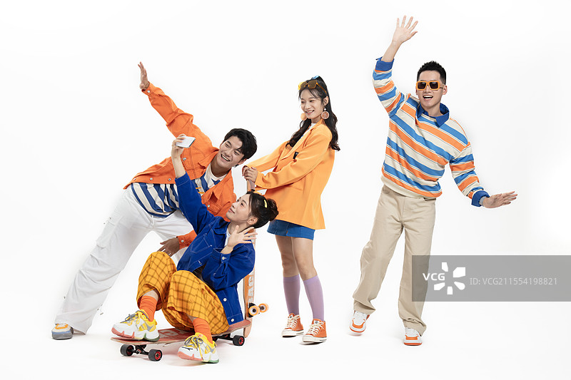 坐在滑板上拍合影的四个年轻男女图片素材
