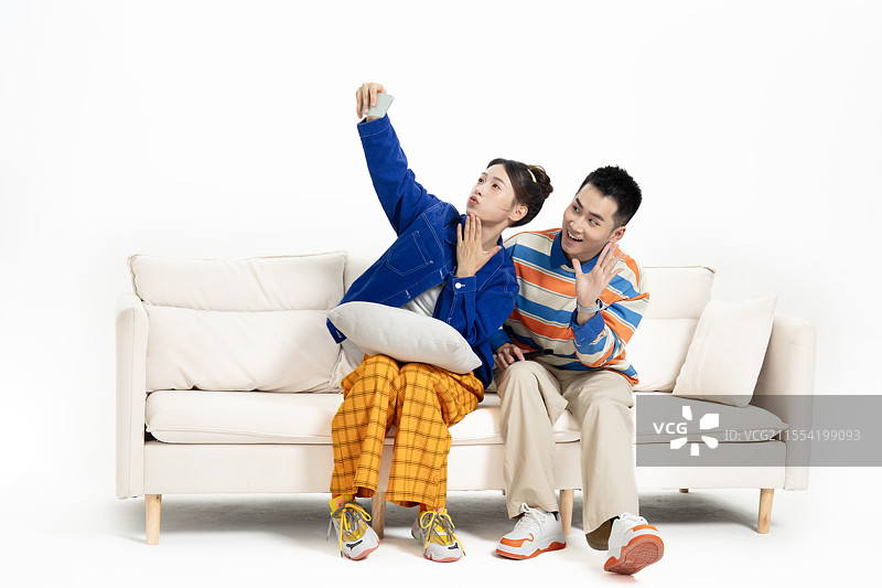 坐在沙发上的一对年轻情侣拍合影图片素材