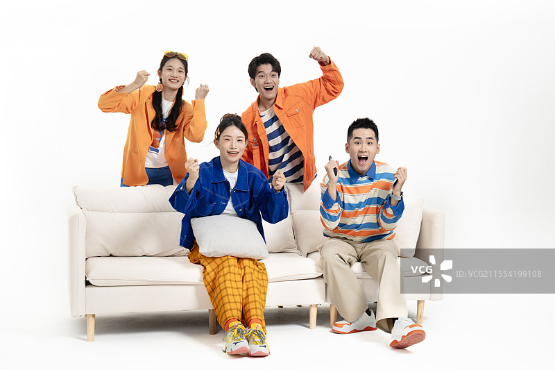在在沙发上看比赛的四个年轻人图片素材