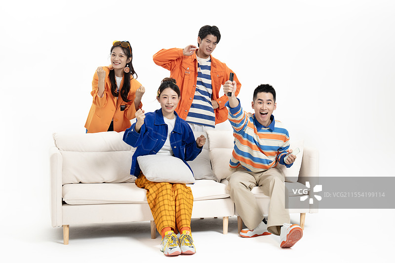 在在沙发上看比赛的四个年轻人图片素材