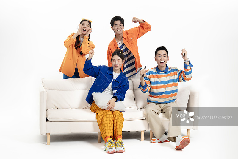 在在沙发上看比赛的四个年轻人图片素材