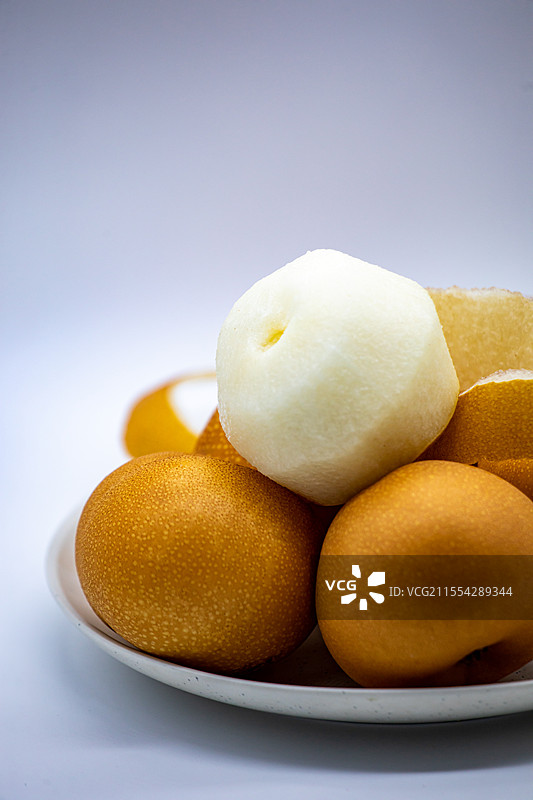 白色背景白色盘子中的山东烟台莱阳特产秋月梨水果特写镜头图片素材