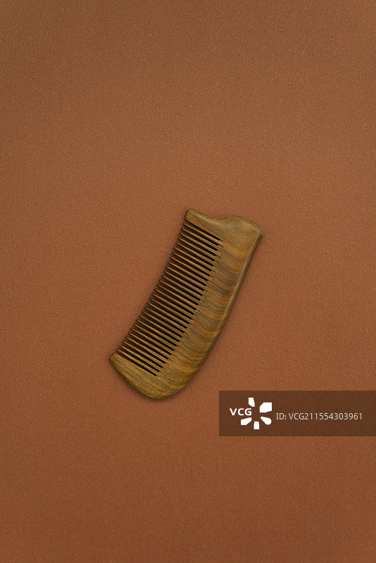 咖色背景上的一把绿檀木梳子图片素材