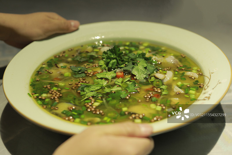 双手端上一份椒麻鱼图片素材