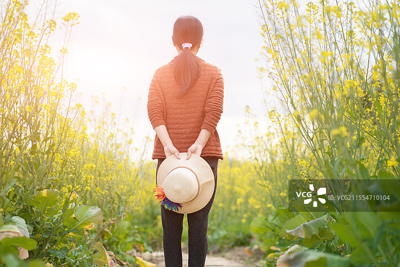 油菜花田赏花踏青的年青女孩图片素材