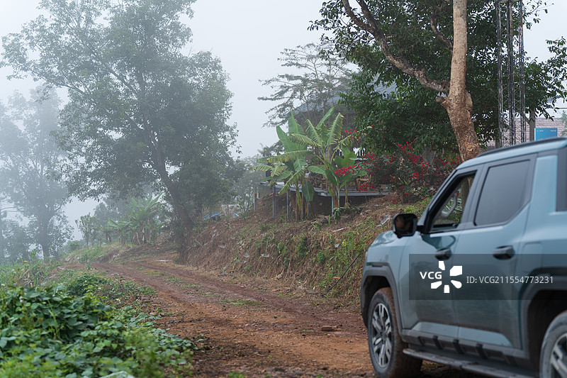 雾中乡村土路旁的SUV汽车图片素材