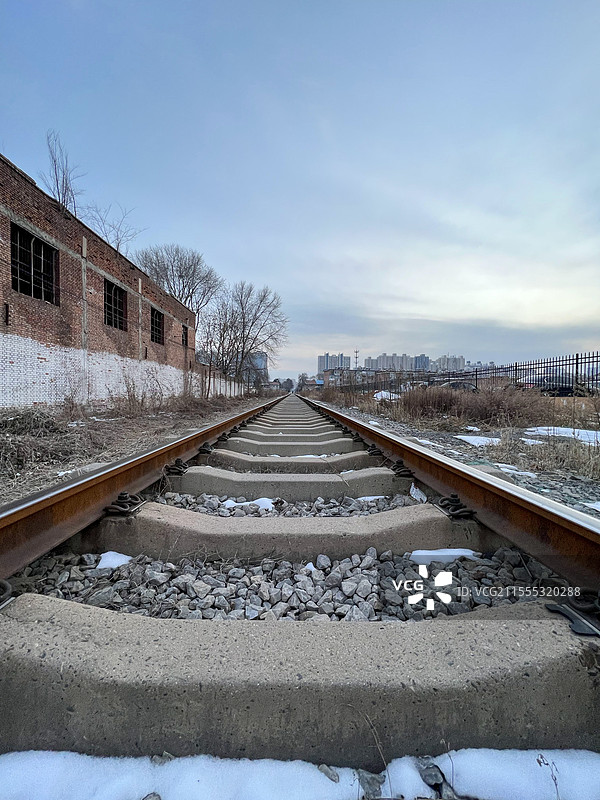 冬日雪覆的废弃铁轨与旧建筑图片素材