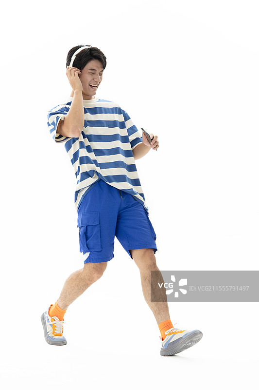 头戴耳机手拿手机听音乐的年轻男人图片素材