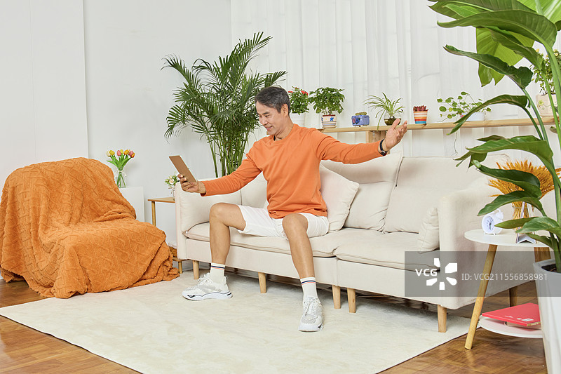 用平板电脑看视频的老年男人图片素材