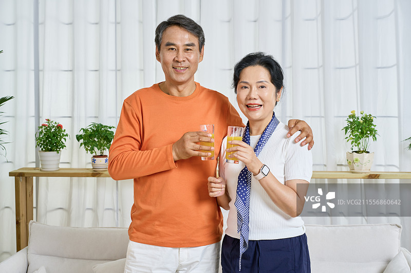 手拿橙果汁的老年夫妻图片素材