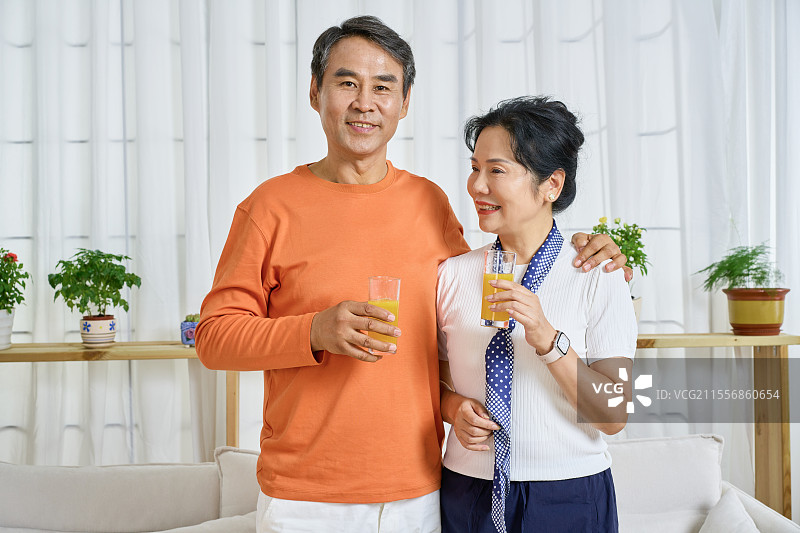 手拿橙果汁的老年夫妻图片素材