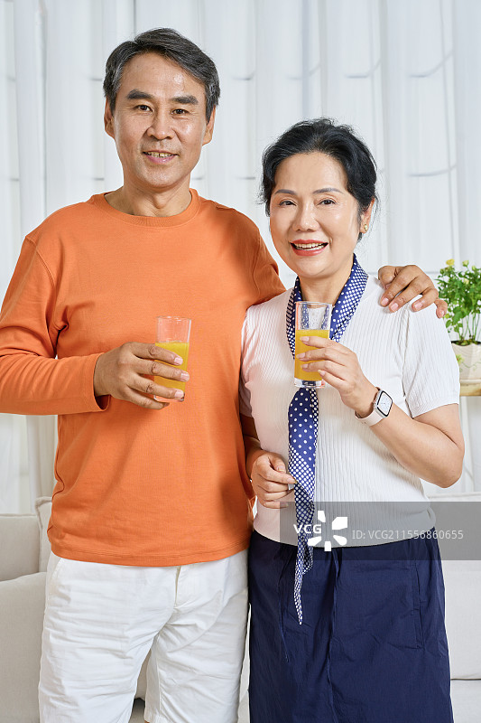 手拿橙果汁的老年夫妻图片素材