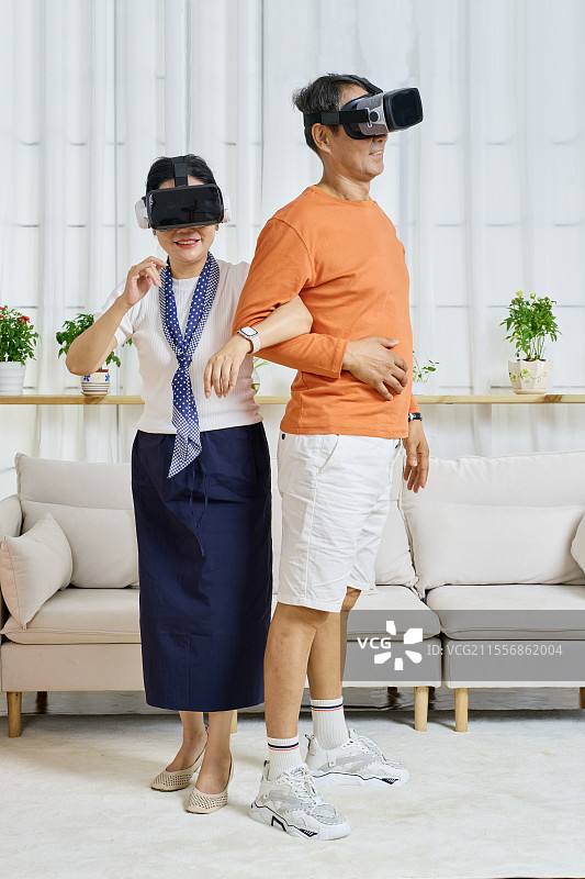 背靠背一起玩VR游戏的老年夫妻图片素材