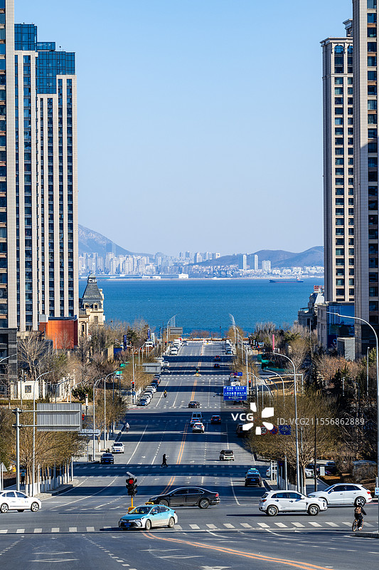 城市车流穿梭，海运巨轮远航，山海相映成趣。图片素材