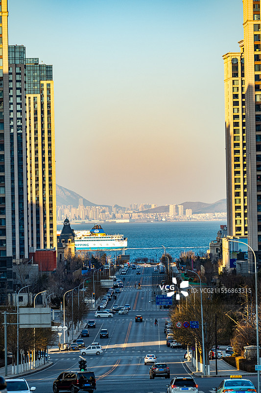 城市车流穿梭，海运巨轮远航，山海相映成趣。图片素材