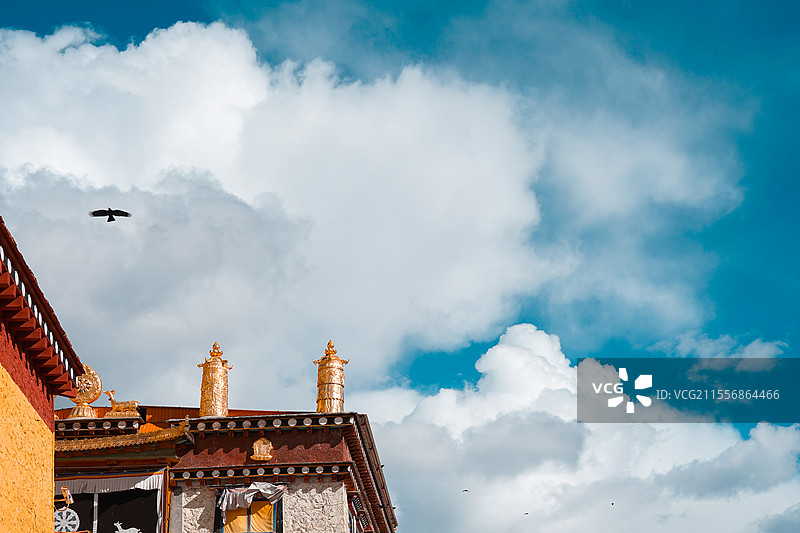 蓝天下的神圣角落：云南高原寺庙屋顶一角与苍鹰的诗意瞬间图片素材