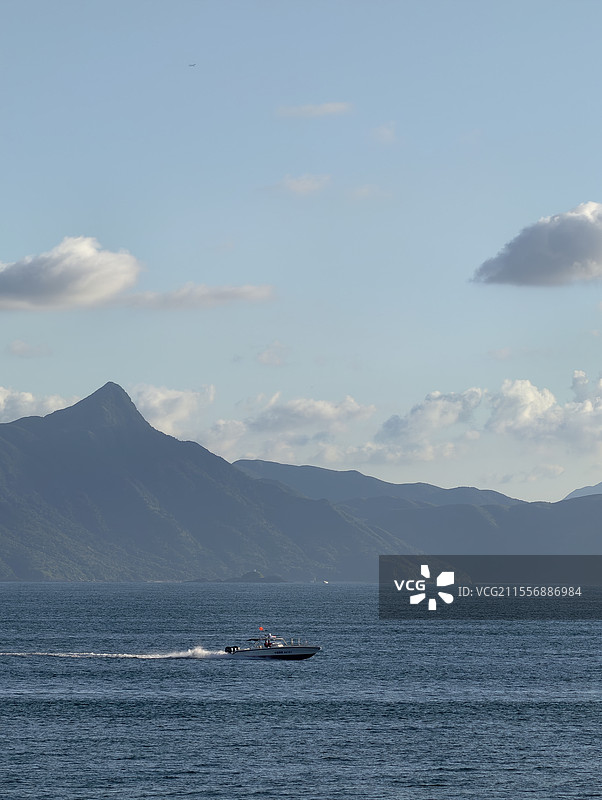 山海相接的海面上有艘快艇图片素材