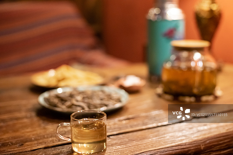 中国休闲娱乐健康生活方式拍摄主题，木制桌子上一堆黄色的锅巴瓜子小吃暖水壶和玻璃杯，室内无人图像摄影图片素材