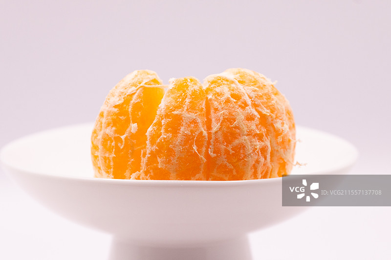 白色背景下盘子里的橘子特写镜头图片素材