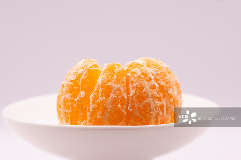 白色背景下盘子里的橘子特写镜头图片素材