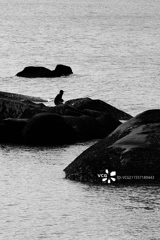 厦门鼓浪屿海上礁石的垂钓者图片素材