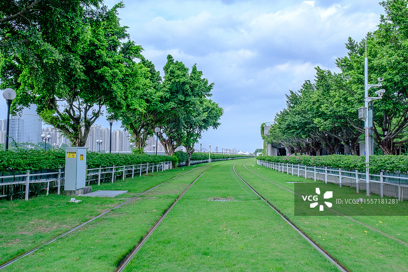 广州城市有轨电车轨道与绿色草坪树林图片素材