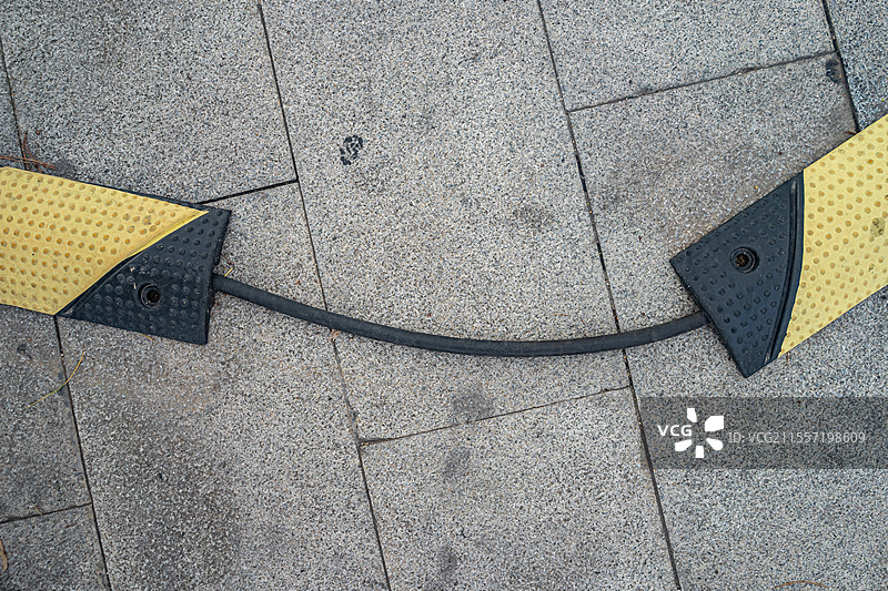 中国道路建设设备用品拍摄主题，覆盖在电缆电线上的橡胶覆盖防止踩踏，户外白昼无人图像摄影图片素材