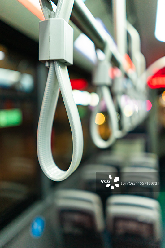 中国公共交通拍摄主题，公交车内部的塑胶材料把手选择对焦前景聚焦特写，户外夜晚无人图像摄影图片素材