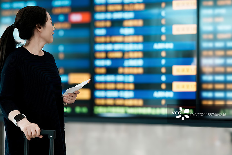 乘客在机场离港登机牌查询航班信息图片素材