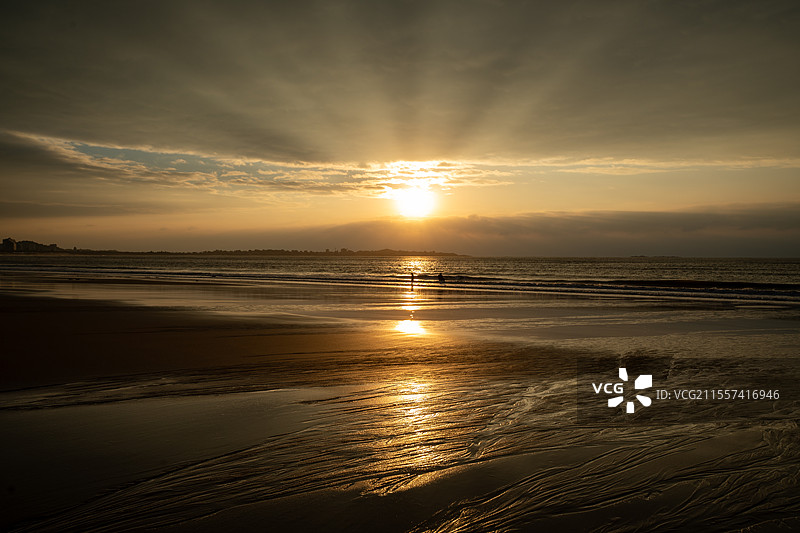 福建泉州玉沙湾沙滩突破云层的日出图片素材