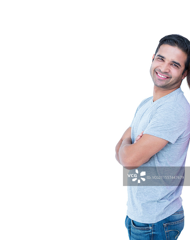自信的男士穿着休闲服装，微笑着双臂交叉，站在办公室中，留有空白空间。图片素材