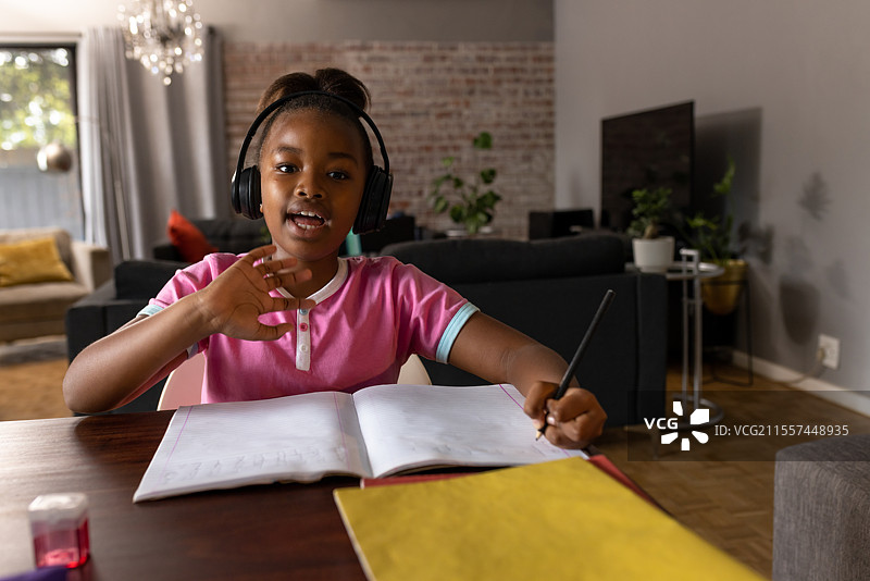 年轻女孩戴着耳机在家学习，参与在线学习，留白空间图片素材