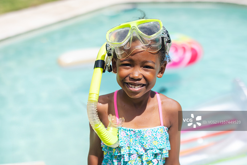 微笑的女孩穿着潜水装备，在游泳池享受夏日时光，留有空白空间图片素材