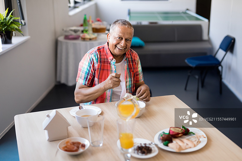 微笑的老年人在养老院的餐厅享用早餐图片素材