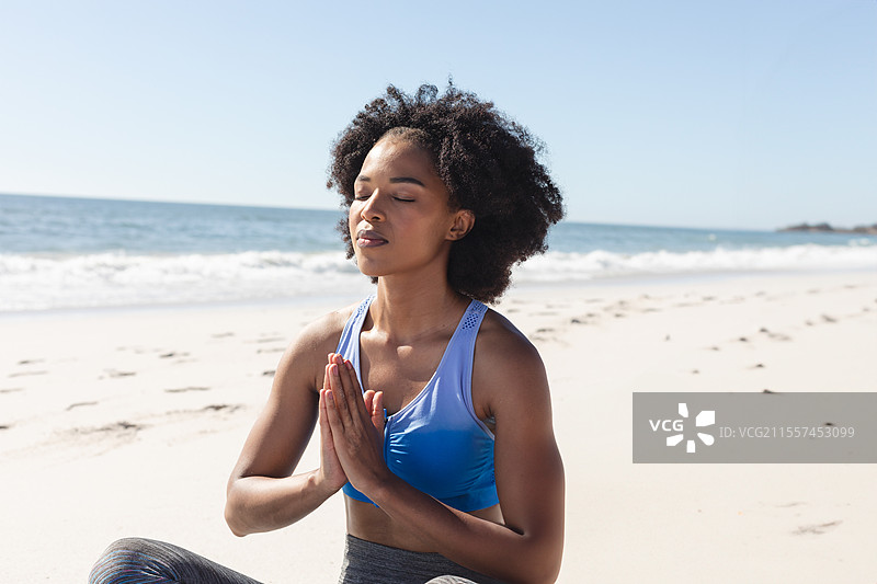 非裔美国女性在海滩上冥想，享受宁静的海洋景色图片素材
