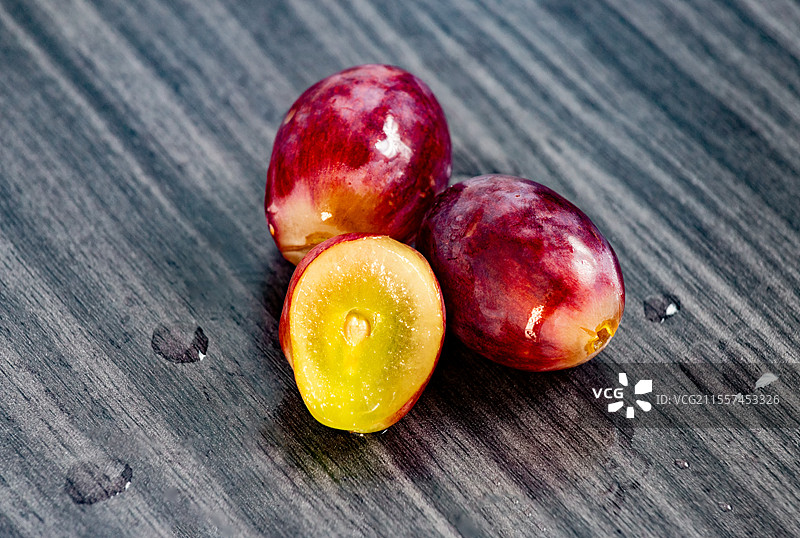 木桌上几颗新鲜的葡萄的特写图片素材