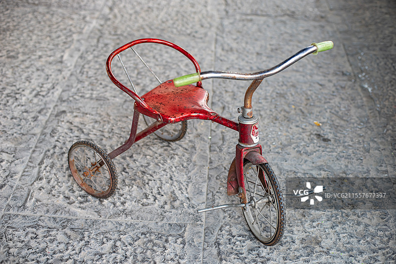 中国传统文化拍摄主题，一辆古典风格复古传统的小孩子骑的铁皮金属三轮车，室内无人图像摄影图片素材